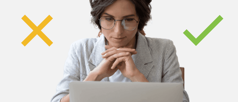 A woman is looking at laptop, thinking about rescinding job offer based on credit check results.