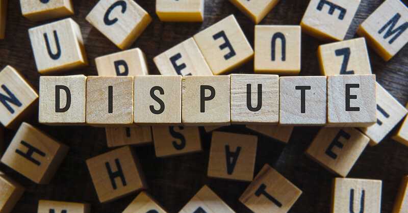 Photo of small wooden blocks spelling the word DISPUTE
