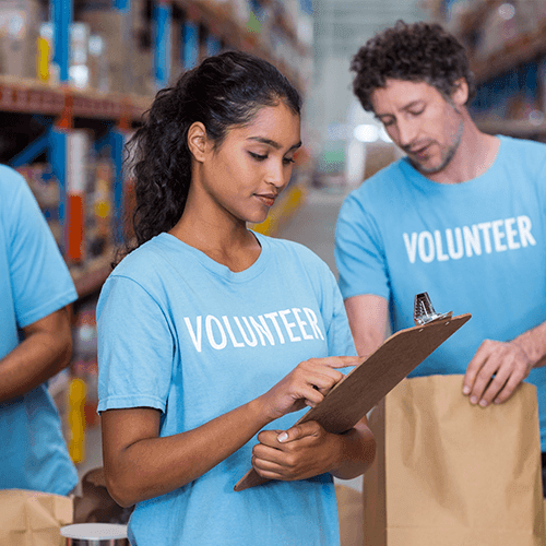 Two volunteers working together in a warehouse