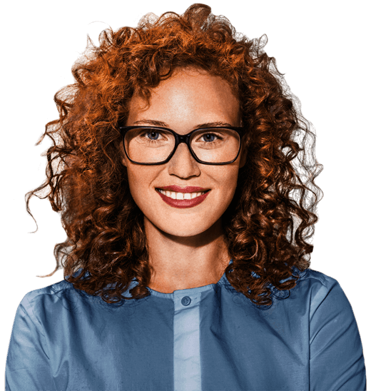 Woman with red curly hair and glasses is smiling at camera
